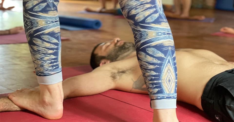 Άτομο δέχεται Thai Yoga Massage σε ένα ήρεμο περιβάλλον.